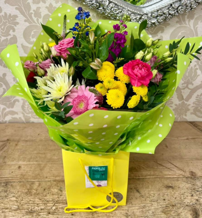 Bright Blooms Bouquet - A cheerful bouquet featuring a mix of vibrant colors, including pinks, yellows, and blues, arranged in a stylish yellow gift bag.