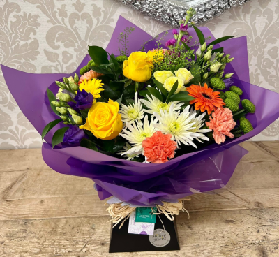 Vibrant Celebration Bouquet - A bold and lively bouquet with a mix of bright oranges, blues, and yellows, elegantly wrapped in paper, perfect for any celebration.
